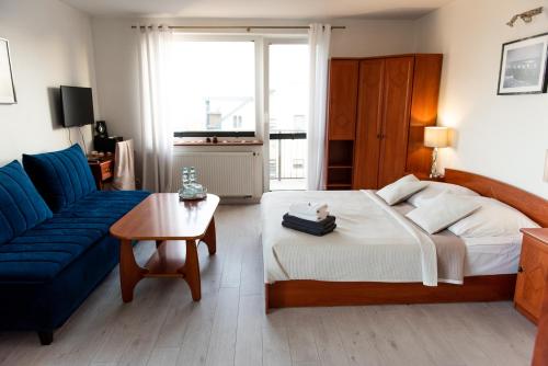 レバにあるVilla Plazowa 6のベッドルーム(大型ベッド1台、青いソファ付)