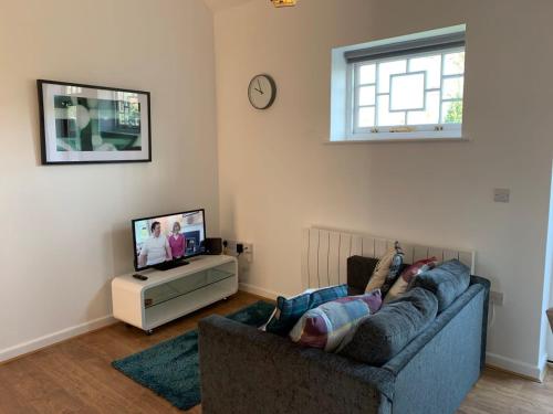 una persona acostada en un sofá en una sala de estar en Ashbrook Lewis - two bedroom, two bathroom cottage nr Harwell Oxford, en Didcot
