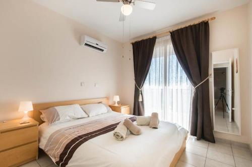 ein Schlafzimmer mit einem großen Bett und einem Fenster in der Unterkunft Royal Seacrest in Paphos City