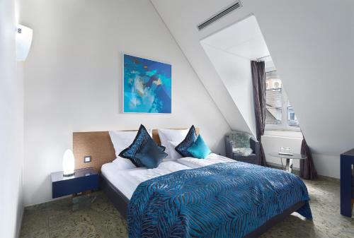 シュリースハイムにあるTRIP INN Kaiser Hotel & Restaurant Heidelberg-Schriesheimの青い毛布が掛けられたベッドのある寝室