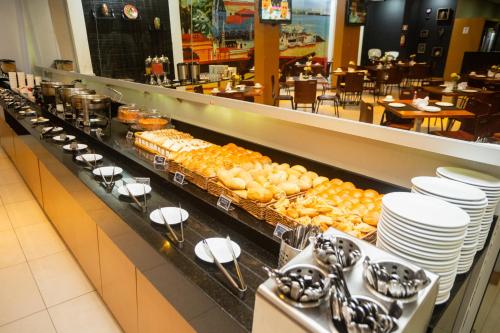 a buffet line with plates and pastries in a restaurant at ibis Styles Belém do Pará in Belém