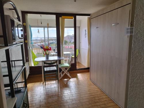 a room with a table and a balcony with a view at Mer - Plage Lazaret in Sète