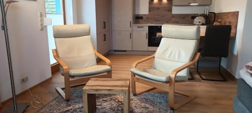 dwa krzesła i stół w kuchni w obiekcie Studioferienhaus Herzogstadt-Celle w mieście Celle