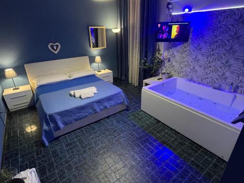 a bedroom with a bed with a tub and a tv at Etnea Glamour House in Catania