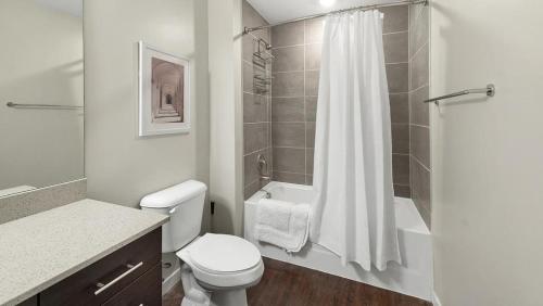 La salle de bains blanche est pourvue d'une douche et de toilettes. dans l'établissement Landing Modern Apartment with Amazing Amenities (ID8377X25), à Orlando