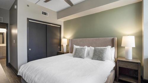 una camera da letto con un grande letto bianco con due lampade di Landing Modern Apartment with Amazing Amenities (ID8404X53) a Mobile