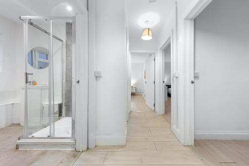 a hallway with white walls and a mirror at Luxury Holiday Home near Kings Cross Sleep 12 SP7 in London