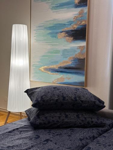 uma cama com um quadro na parede e uma almofada em Viesu māja V.Seiles ielā em Rezekne