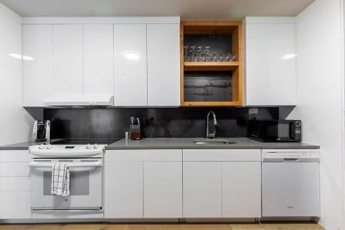 eine weiße Küche mit Herd und Spüle in der Unterkunft Landing Modern Apartment with Amazing Amenities (ID4754X66) in Portland