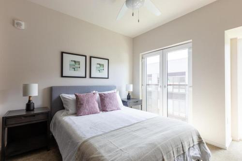 ein weißes Schlafzimmer mit einem großen Bett mit rosa Kissen in der Unterkunft Landing Modern Apartment with Amazing Amenities (ID4754X66) in Portland