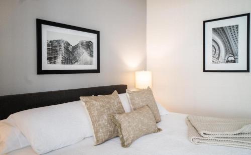 1 dormitorio con 1 cama con 2 cuadros en la pared en Landing Modern Apartment with Amazing Amenities (ID7301), en Durham
