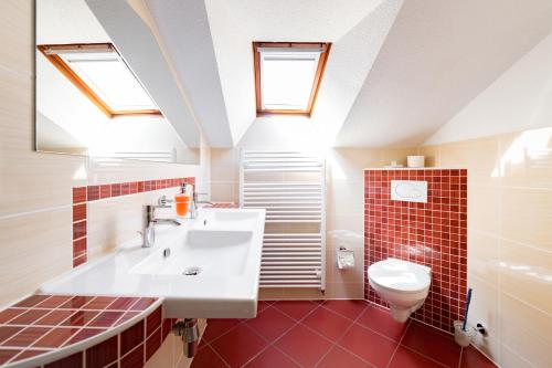 Łazienka z umywalką oraz toaleta z świetlikami w obiekcie Hotel & Ferienwohnungen Bohlenblick w mieście Saalfeld/Saale