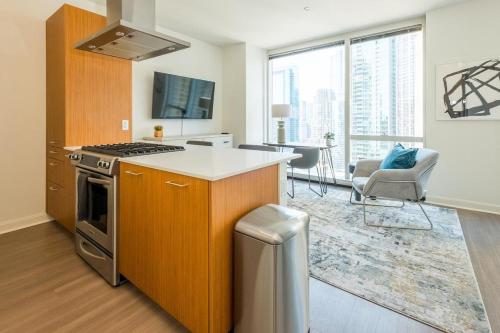 an apartment kitchen with a stove and a living room at Landing Modern Apartment with Amazing Amenities (ID634) in Chicago