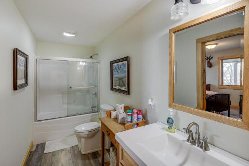 y baño con lavabo, aseo y espejo. en Yankton Vacation Home with Hot Tub and River Views, en Yankton