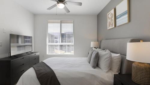 a bedroom with a bed with a ceiling fan and a television at Landing Modern Apartment with Amazing Amenities (ID8777X46) in San Diego