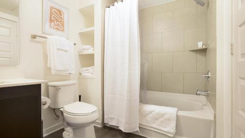 La salle de bains blanche est pourvue de toilettes et d'une baignoire. dans l'établissement Landing Modern Apartment with Amazing Amenities (ID8777X46), à San Diego