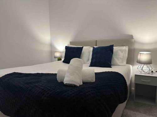 a bedroom with a large bed with towels on it at Modern Elegance 2-Bedroom Apartment in Bolton