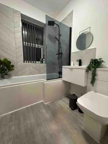 a bathroom with a sink and a shower and a toilet at Modern Elegance 2-Bedroom Apartment in Bolton