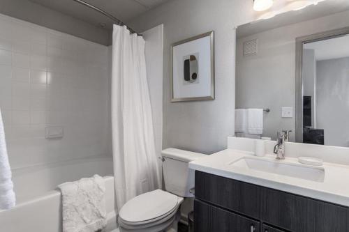 een witte badkamer met een toilet en een wastafel bij Landing Modern Apartment with Amazing Amenities (ID4174X27) in Austin