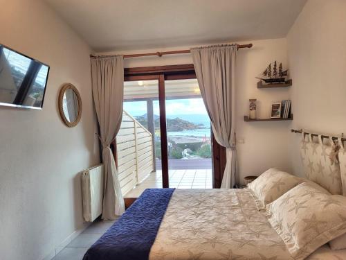 a bedroom with a bed with a view of a balcony at B&B Mistral in Santa Teresa Gallura