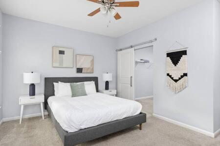 a bedroom with a bed and a ceiling fan at CozySuites l Dream 1BR, Monument Circle, Indy in Indianapolis