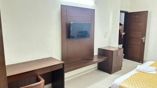 a hotel room with a tv and a bedroom at Hotel Green Lotus By Dsy Hospitality in Noida