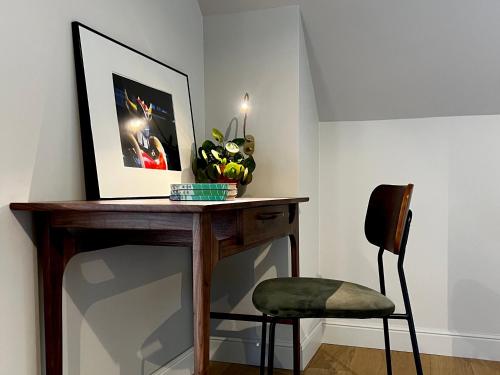 a table and a chair in a room at Historic 18th-Century Mansion - 3 BR - Bayeux - Garden & Museums Nearby in Bayeux