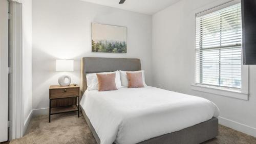 a white bedroom with a large bed and a night stand at Landing Modern Apartment with Amazing Amenities (ID9518X91) in San Antonio