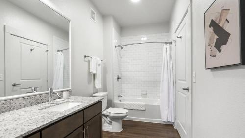 a white bathroom with a toilet and a sink at Landing Modern Apartment with Amazing Amenities (ID9518X91) in San Antonio