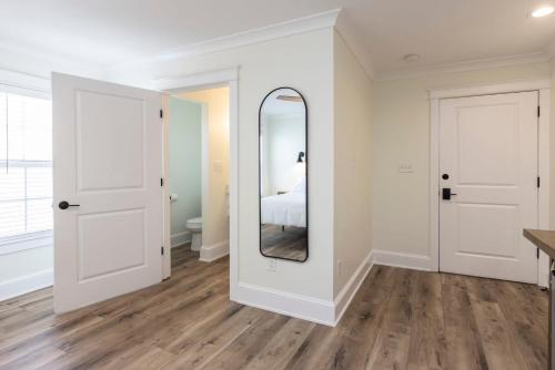 een witte kamer met een spiegel en een bed bij Albermarle #202 Inn at Old Beach in Virginia Beach