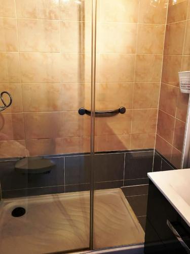 une douche avec une porte vitrée dans une salle de bain dans l'établissement charmant appartement à deux pas de la mer, à La Grande Motte