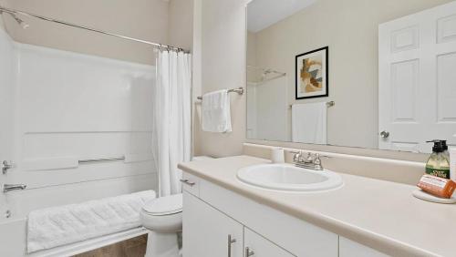 a white bathroom with a sink and a toilet at Landing Modern Apartment with Amazing Amenities (ID1981X99) in Greensboro