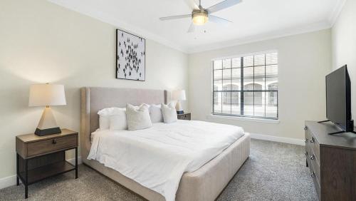 ein weißes Schlafzimmer mit einem Bett und einem TV in der Unterkunft Landing Modern Apartment with Amazing Amenities (ID3050X22) in Houston