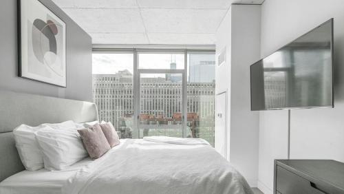 a bedroom with a white bed and a large window at Landing Modern Apartment with Amazing Amenities (ID8152X03) in Chicago