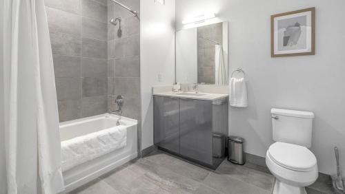 a bathroom with a tub and a toilet and a sink at Landing Modern Apartment with Amazing Amenities (ID8152X03) in Chicago