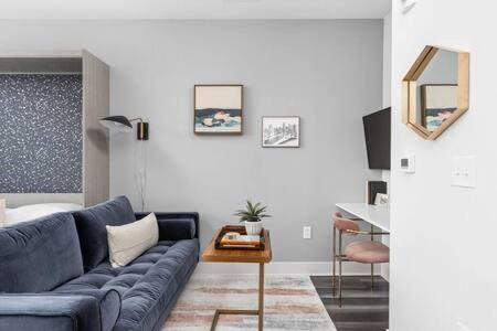 a living room with a blue couch and a table at CozySuites Studio Apartment in Urban Indy in Indianapolis
