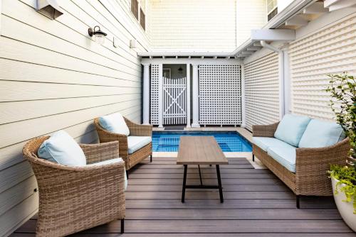 a patio with wicker chairs and a table and a pool at Albermarle #202 Inn at Old Beach in Virginia Beach