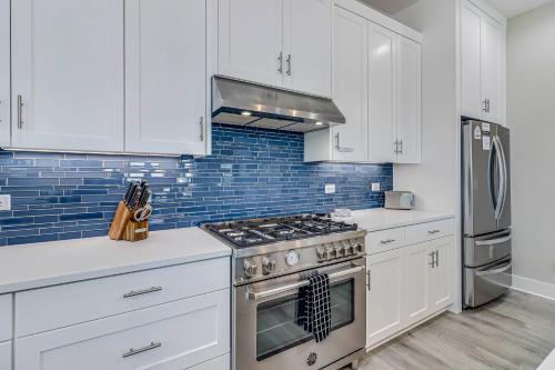 a kitchen with white cabinets and a stove top oven at The Water Way in Rockport