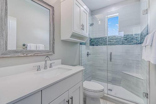 a white bathroom with a toilet and a shower at The Water Way in Rockport