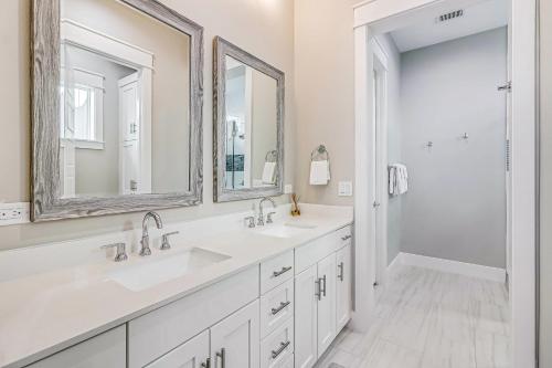 a white bathroom with two sinks and a shower at The Water Way in Rockport