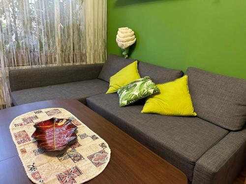 a couch with yellow pillows in a living room at Luxury Oasis in absolute Center of Sofia in Sofia
