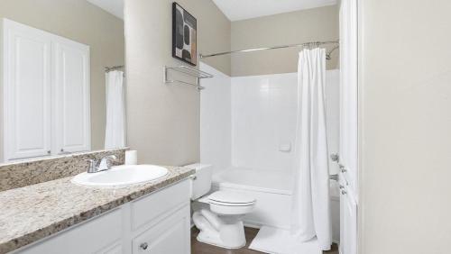 Baño blanco con aseo y lavamanos en Landing Modern Apartment with Amazing Amenities (ID9507X17) en Memphis