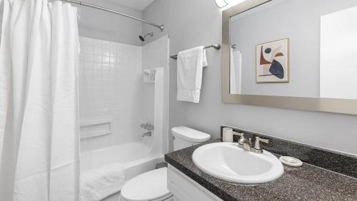 uma casa de banho branca com um lavatório e um WC em Landing Modern Apartment with Amazing Amenities (ID1222X839) em High Point