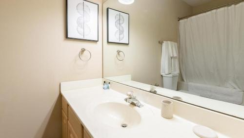een witte badkamer met een wastafel en een spiegel bij Landing Modern Apartment with Amazing Amenities (ID8089X06) in Louisville