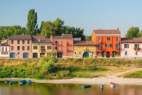 un gruppo di edifici sul fiume con barche in acqua di BORGO TICINO SUITE Attico di Lusso con Terrazzo e Parking Privato a Pavia