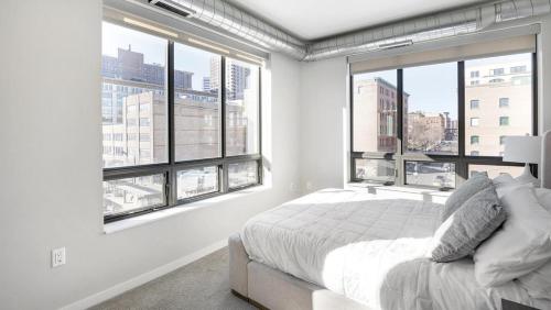 1 dormitorio blanco con ventanas grandes y 1 cama en Landing Modern Apartment with Amazing Amenities (ID1231X251), en Saint Paul