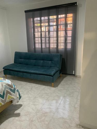 a blue couch in a living room with a window at Hermosa Casa Central - Rositas's house in La Mesa