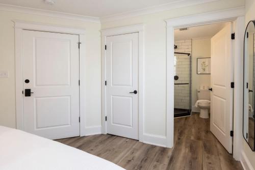 Dormitorio blanco con puertas blancas y aseo en Breakers 204 Inn at Old Beach en Virginia Beach