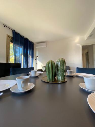 a table with plates and cups and a cactus on it at Cortemaggiore 4B Luxury-Flexrent Abissinia in Riccione