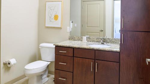 a bathroom with a toilet and a sink and a mirror at Landing Modern Apartment with Amazing Amenities (ID8210X91) in Orlando